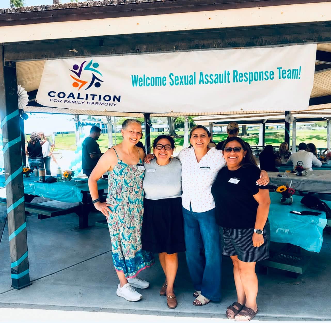 Coalition team under a 'Welcome Sexual Assault Response Team' banner at a community gathering